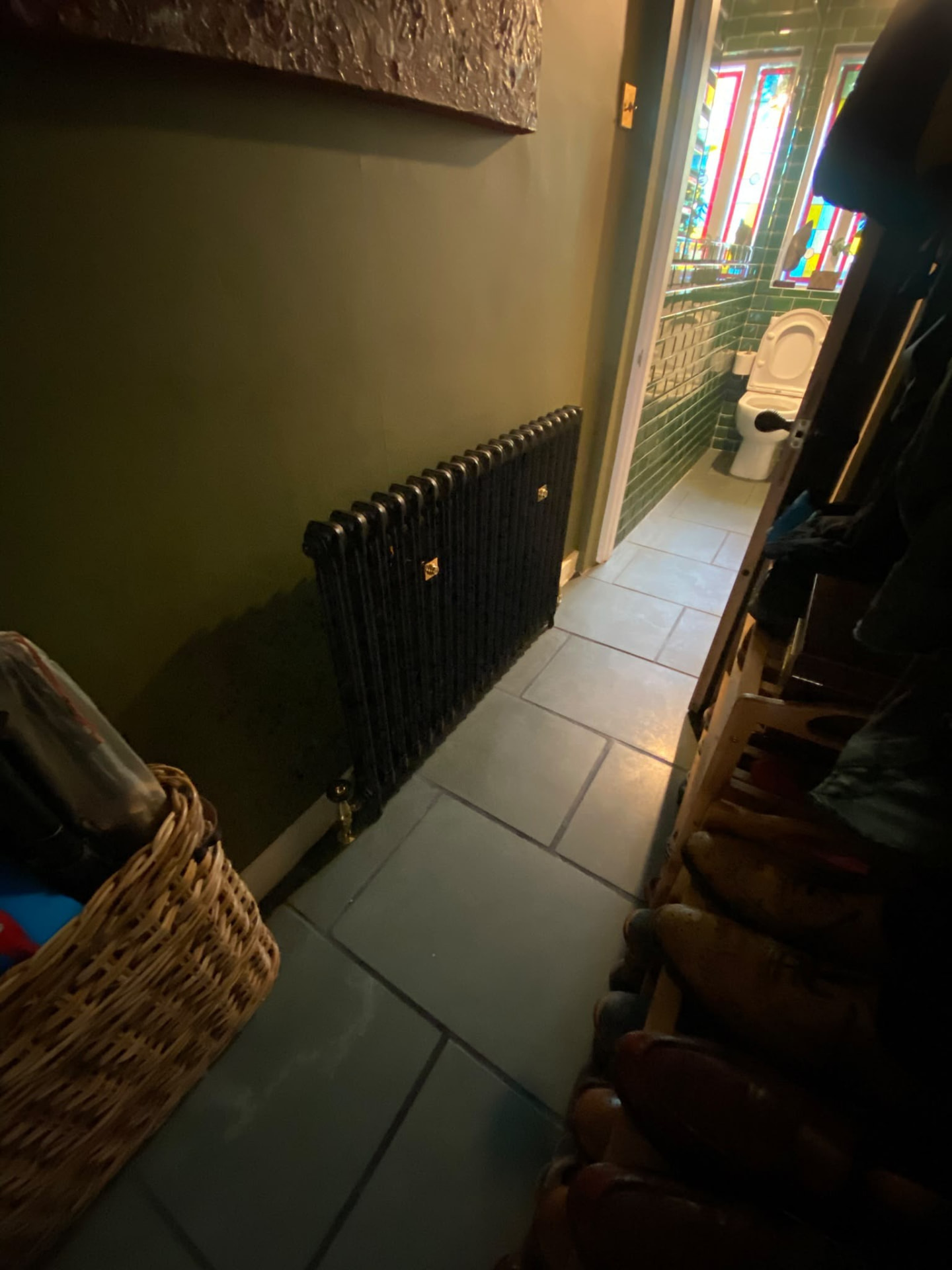 Traditional black cast iron column radiator installed in a London hallway