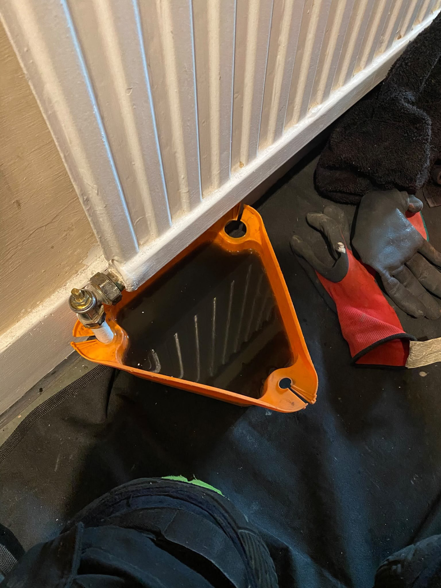 Radiator drained showing black sludge water during a London powerflush
