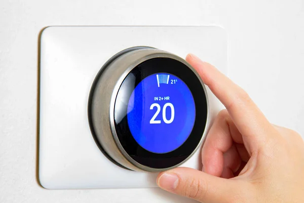 Modern smart heating thermostat installed on a wall in a London home