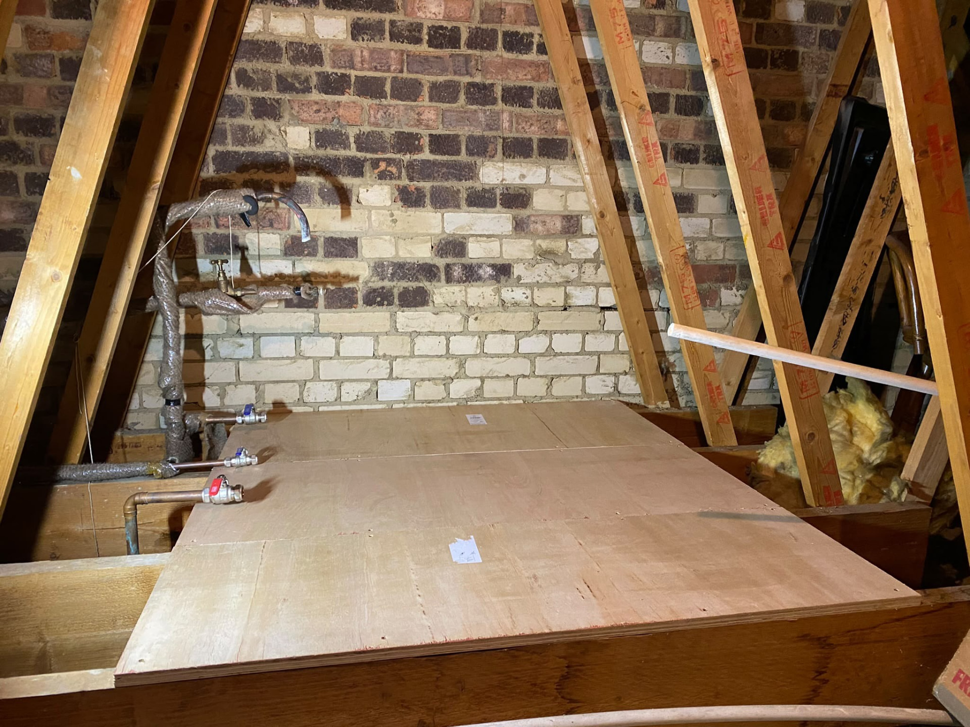 Loft platform prepared with copper pipe tails for a new cold water tank in London