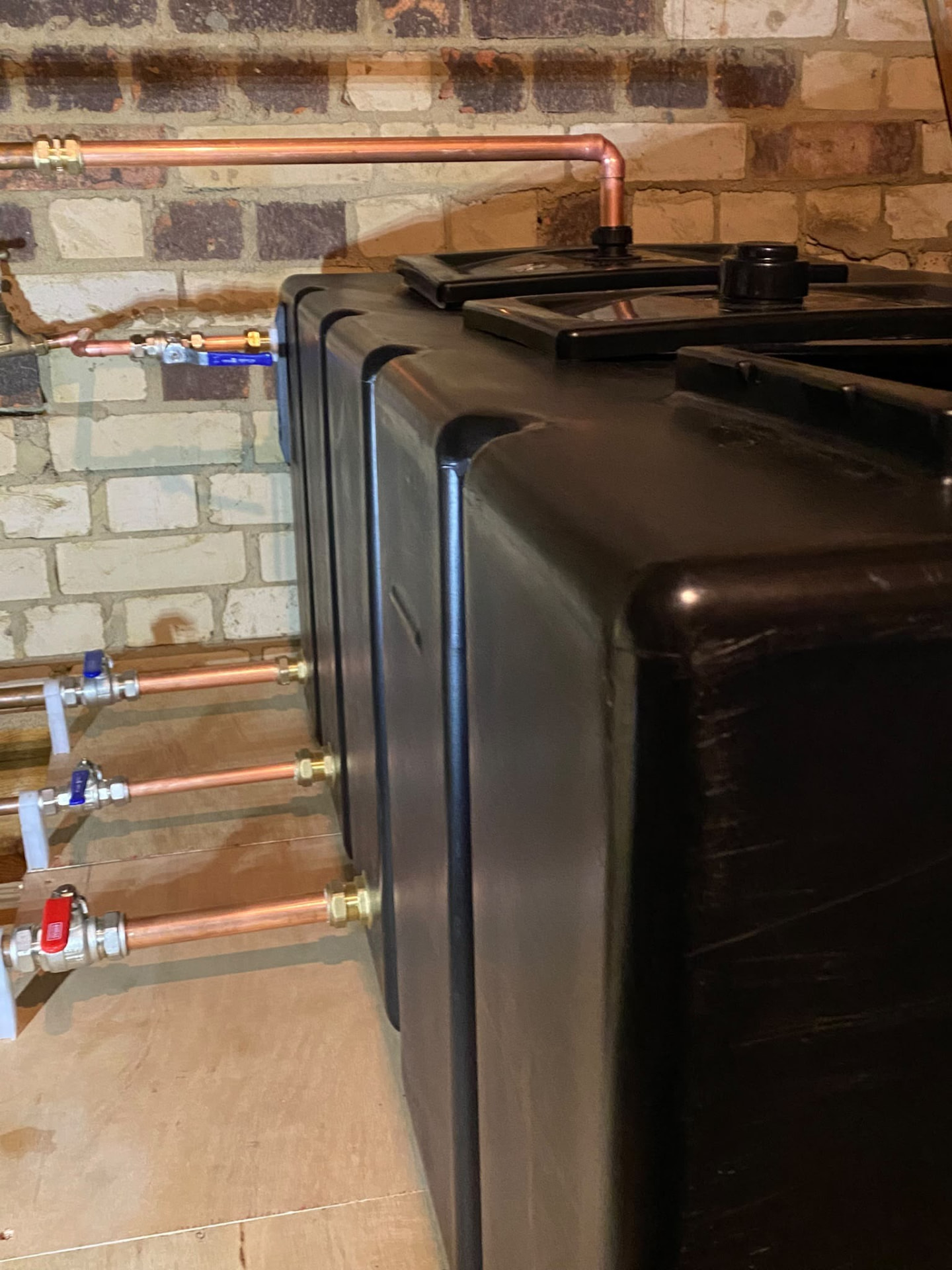 Close-up of connections on a new cold water storage tank in a London loft