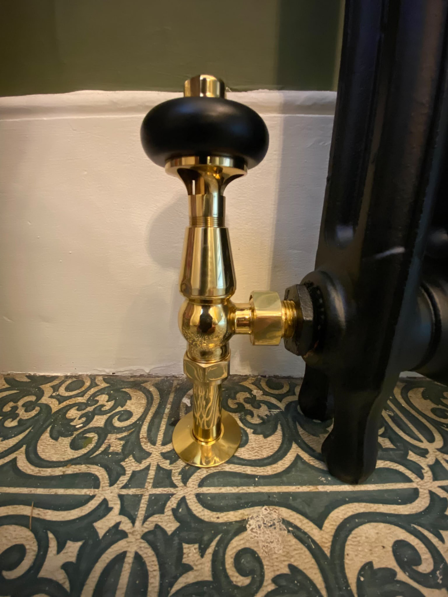 Brass radiator lockshield valve with black hardwood handle installed in London