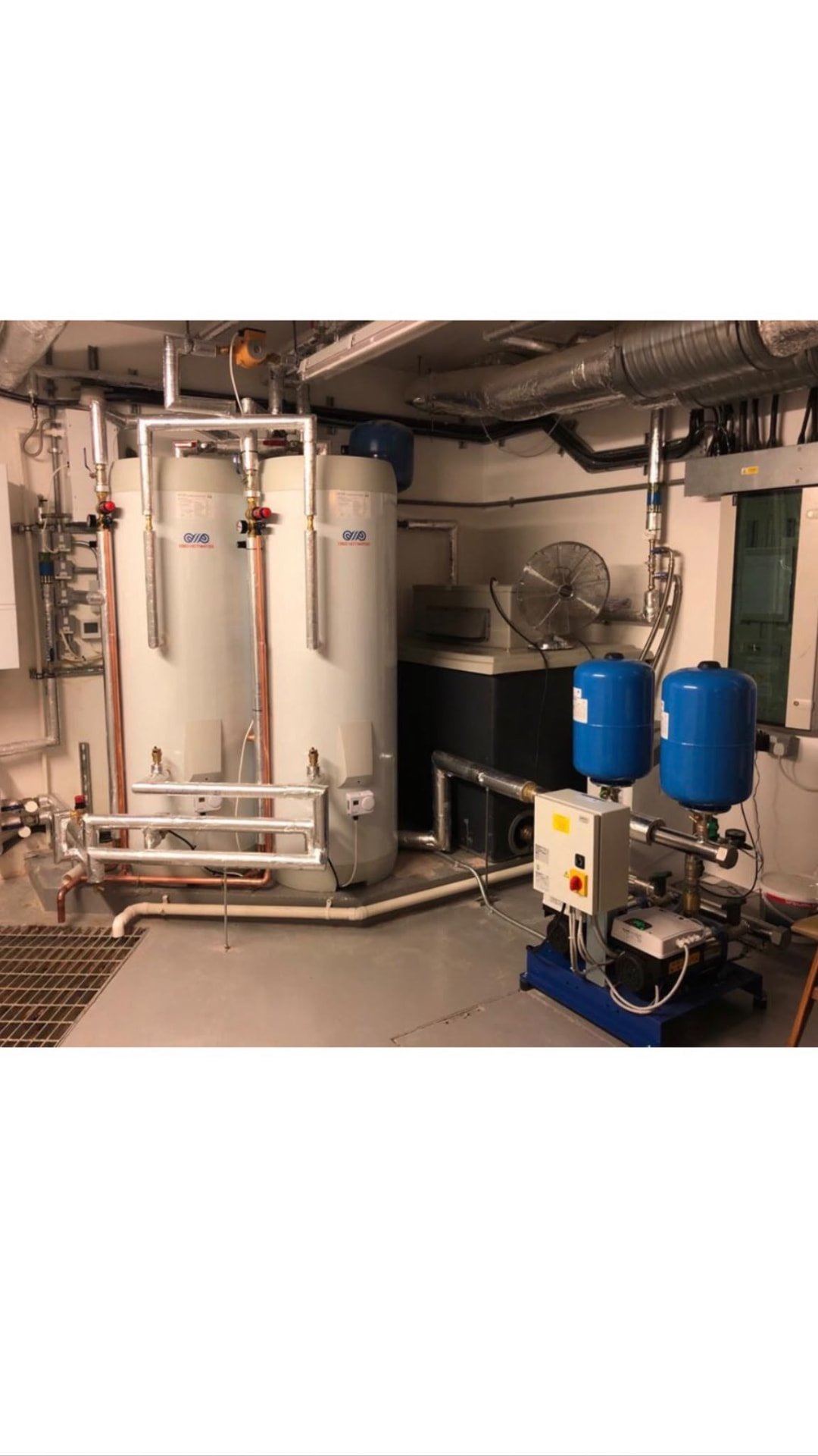 Commercial hot water cylinders with twin booster pumps installed in a London plant room